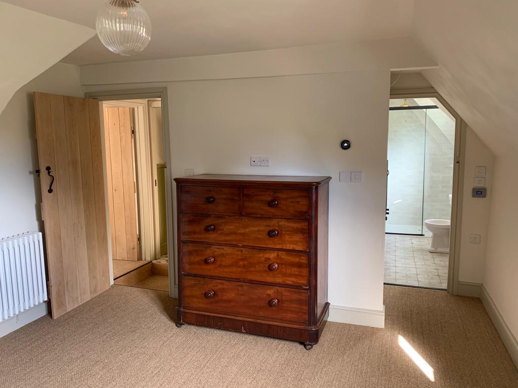Cottage bedroom with sloping ceiling and new en suite shower room completed by Two Build